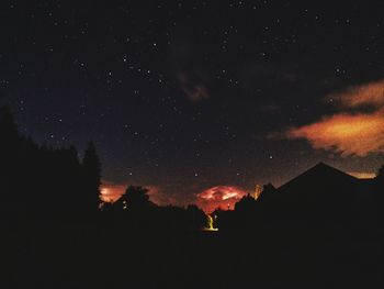 Low angle view of silhouette trees against sky at night