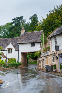 Houses by river against buildings