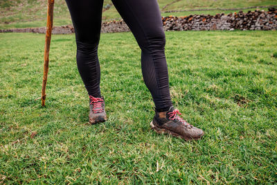 Low section of woman standing on grassy field