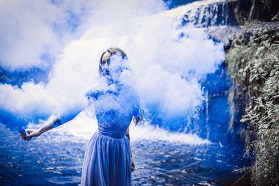 Woman standing in water against blue sky