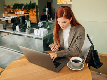 Young woman using laptop at table