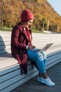 Side view of woman sitting on staircase