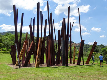 Panoramic view of wooden posts on field against sky