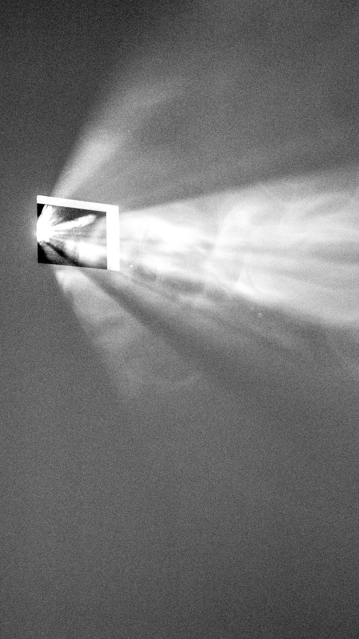 LOW ANGLE VIEW OF ILLUMINATED LIGHT ON WALL AGAINST SKY