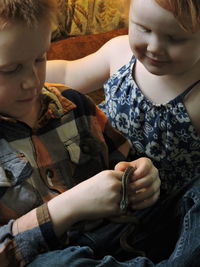 Friends playing with small snake at home