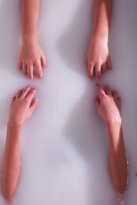 Cropped hands of women in bathtub