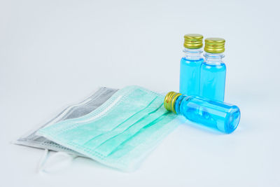 High angle view of bottles on table against white background