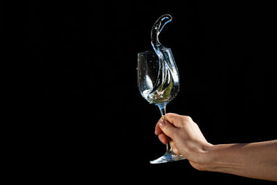 Person holding ice cream against black background