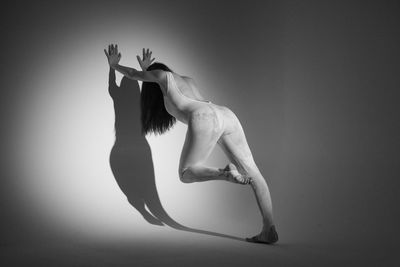 Side view of a woman against black background