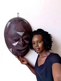 Portrait of smiling woman standing against white background