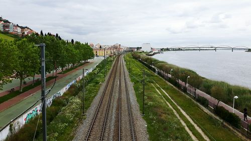 Bridge over river in city against sky