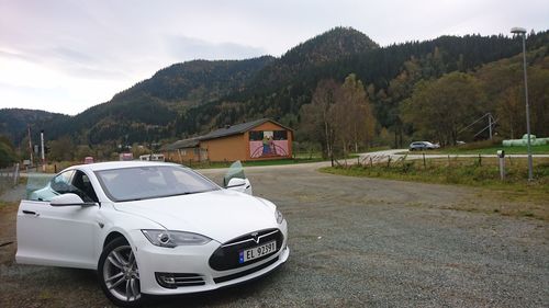 Car on road by mountain against sky