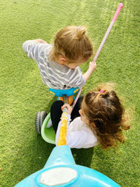 High angle view of girl playing with toy on grassy field