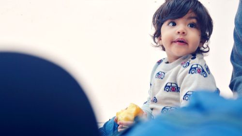 Portrait of cute boy looking away at home