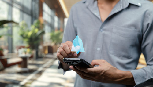 Midsection of man using mobile phone