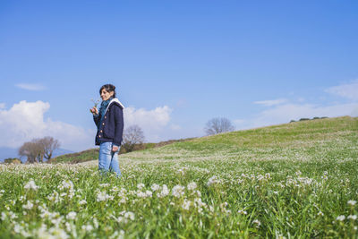 Woman standing on field against sky