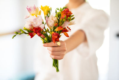 Midsection of woman holding flowers