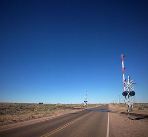 Road in desert against clear blue sky