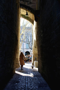 People in alley amidst buildings in city