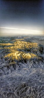 Aerial view of dramatic landscape against sky during winter