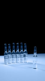 Medicine bottles on table against black background