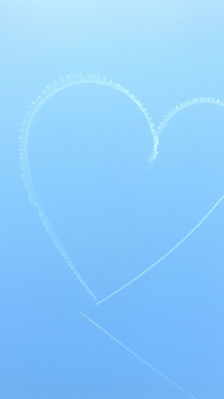 blue, low angle view, mid-air, vapor trail, flying, clear sky, sky, copy space, multi colored, nature, beauty in nature, circle, no people, scenics, motion, outdoors, rainbow, day, tranquility, adventure