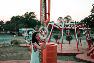 Woman holding rings while standing at park