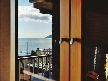 View of restaurant by sea against sky seen through window