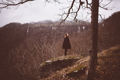 Rear view of woman walking on field