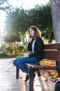 Young woman sitting on bench at park
