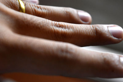 Extreme close up of man's fingers with golden ring