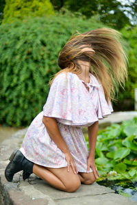 Rear view of girl sitting outdoors