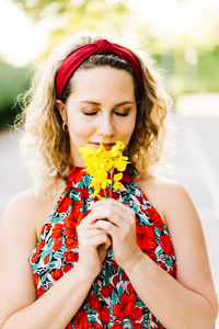 Beautiful young woman holding flower head