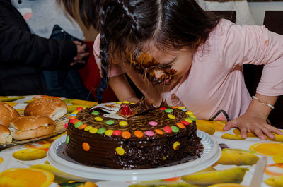 Girl with cake on face during birthday party