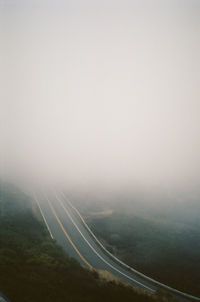 Scenic view of road against sky during foggy weather