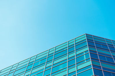 Low angle view of modern building against clear blue sky