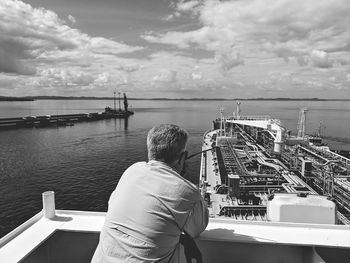 Rear view of man looking at sea against sky