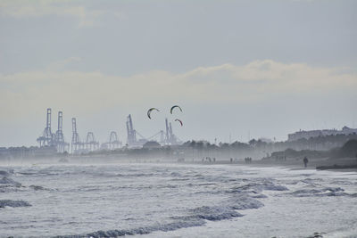 Harbor cranes with giant kites in front. colors of nature