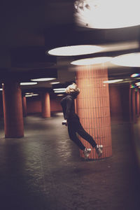 Woman in mid-air at illuminated basement