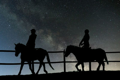 Silhouette man riding horse