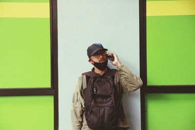 Portrait of man standing against wall