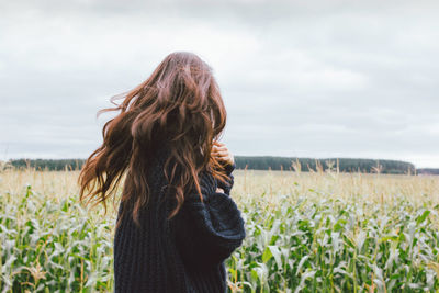 Rear view of woman standing on field