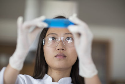 Scientist female with lab glasses and tubes in a lab