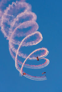 Low angle view of airplane flying against blue sky