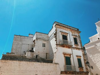 Low angle view of old building against clear blue sky