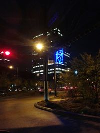 Road passing through illuminated city at night