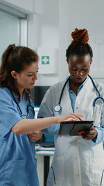 Female doctor and nurse using digital tablet in office