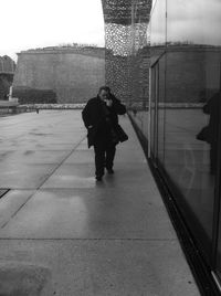 Full length rear view of man walking on snow covered landscape