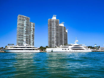 Modern building by sea against clear blue sky