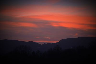 Scenic view of silhouette mountains against romantic sky at sunset